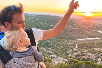 Mann mit Kleinkind in einer Babytrage