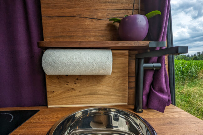 Kuechenrueckwand mit Papierhalter und Spuele